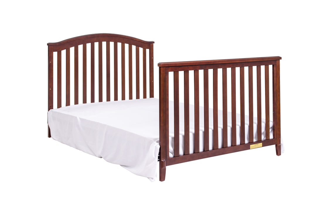 Wooden crib with white mattress on a white background
