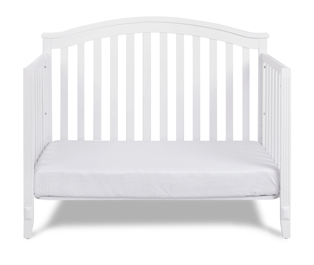 White crib with a white mattress on a white background