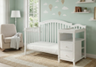 Nursery room with white crib and changing table against a light green wall.