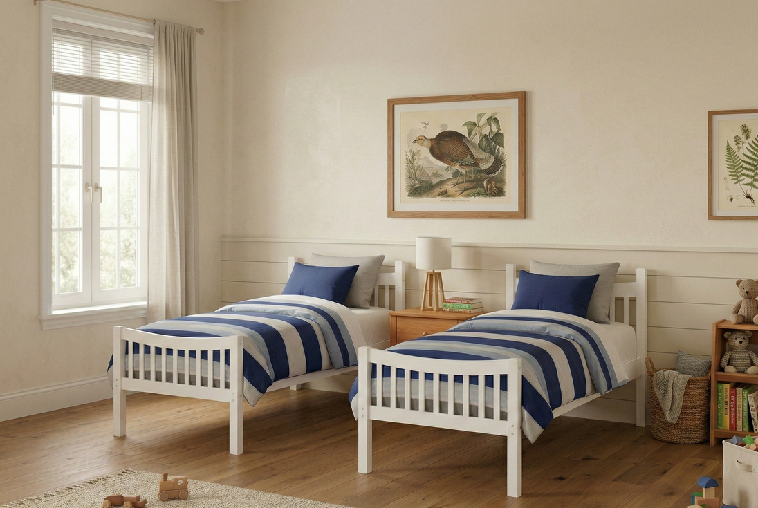 Children's bedroom with two beds, toys, and framed pictures on a white wall.